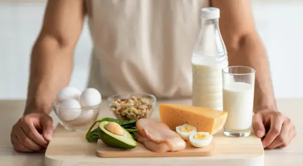 Jak uzupełnić wapń zjonizowany? Na stole produkty bogate w wapń: mleko, ser, jajka, orzechy, awokado i szpinak.