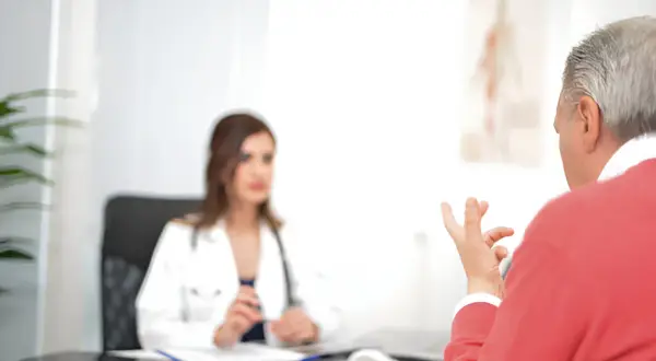Lekarz omawia z pacjentem objawy menopauzy u mężczyzn.